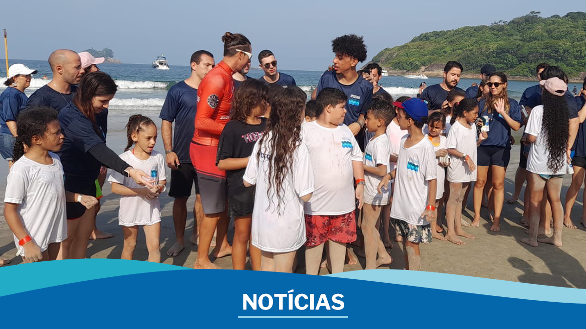 Foto de crianças e voluntários (adultos) na praia, com o texto "Notícias"